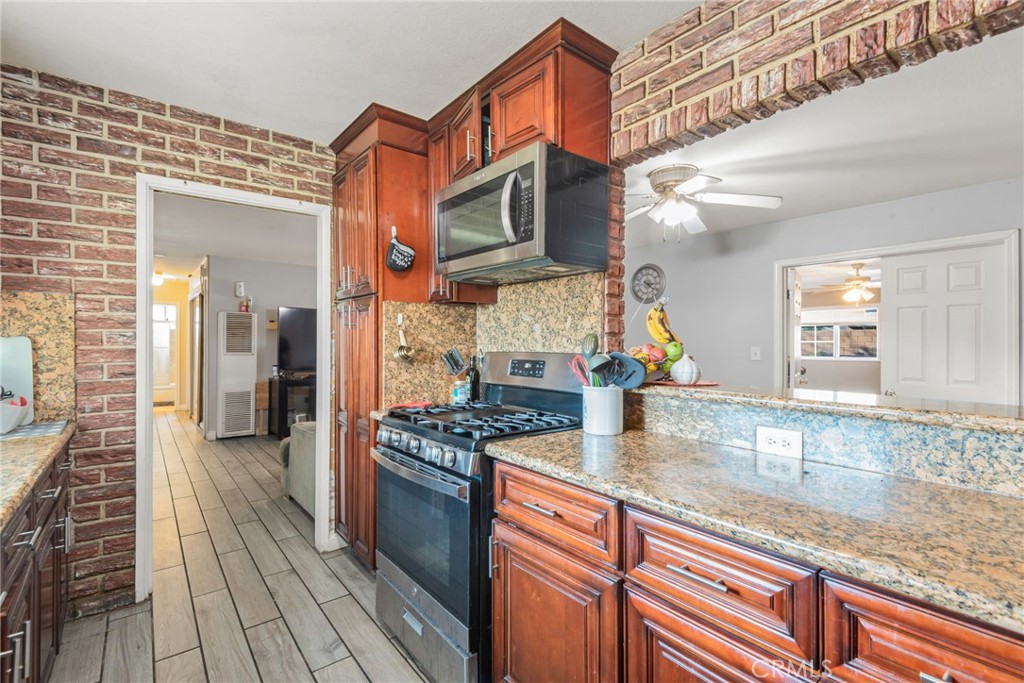 19450 Woodhill Street Rialto, CA 92376 - Photo 14 of 51 a kitchen with stainless steel appliances granite countertop a stove and a sink