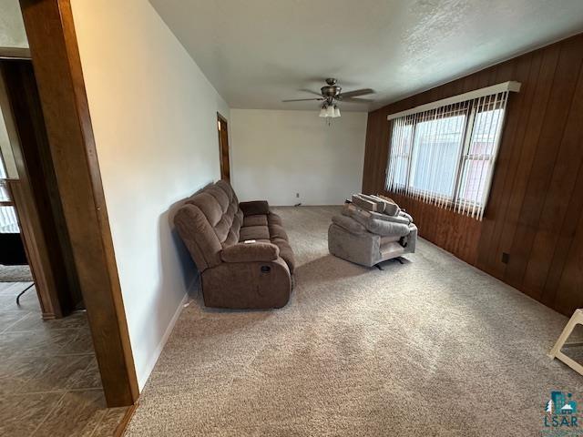 30 Fir Circle Babbitt, MN 55706 - Photo 12 of 27 Living area with carpet flooring, a ceiling fan, and wood walls