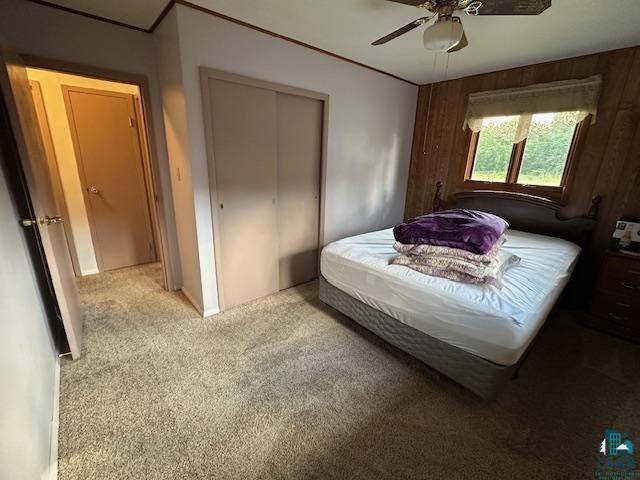 30 Fir Circle Babbitt, MN 55706 - Photo 14 of 27 Bedroom featuring carpet flooring, a closet, wooden walls, and ceiling fan