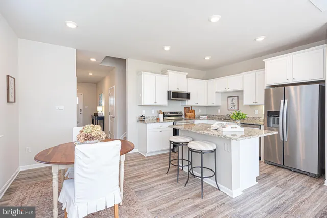 a kitchen with stainless steel appliances kitchen island granite countertop a sink a stove and a microwave