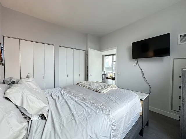 a bedroom with a bed and a flat screen tv