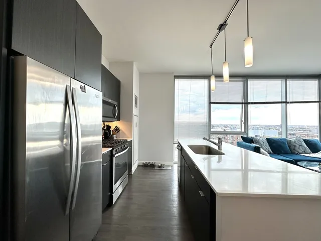 a kitchen with stainless steel appliances granite countertop a sink a refrigerator and window