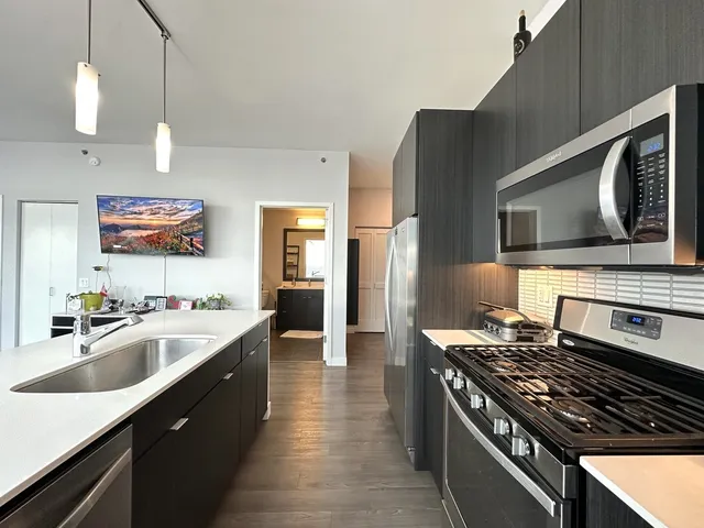 a kitchen with sink stove and refrigerator