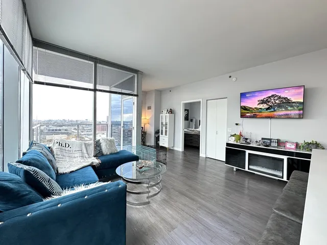a living room with furniture kitchen view and a large window