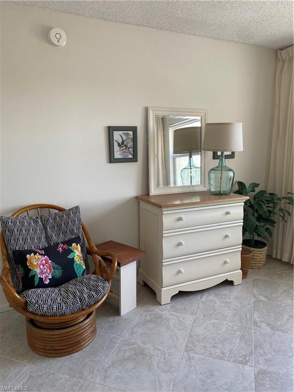 3 Bluebill Avenue, Unit 609 Naples, FL 34108 - Photo 12 of 15 Living area featuring a textured ceiling