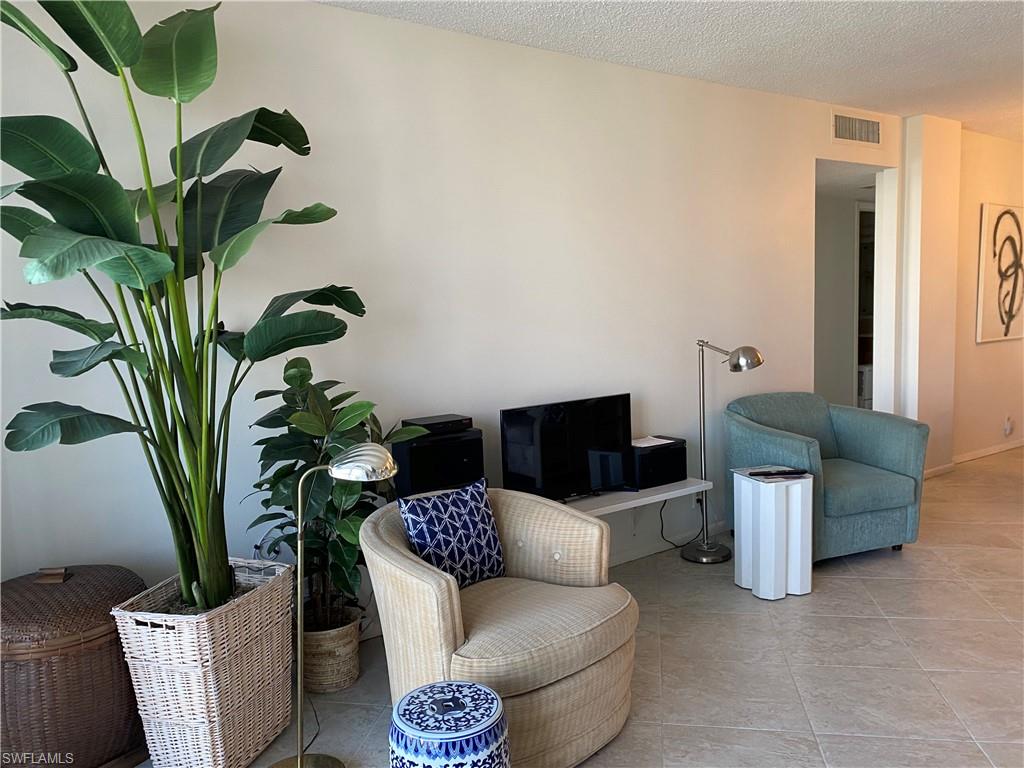 3 Bluebill Avenue, Unit 609 Naples, FL 34108 - Photo 14 of 15 Living area with light tile patterned floors and a textured ceiling