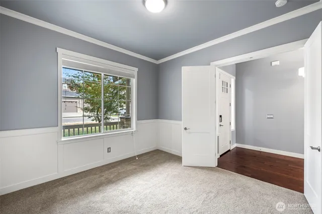 an empty room with wooden floor chandelier and windows