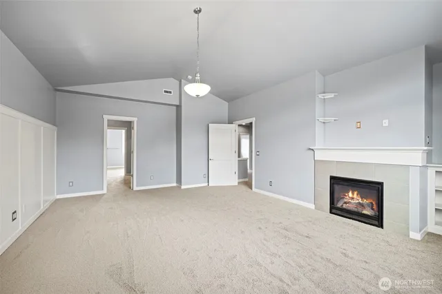 an empty room with windows and fireplace