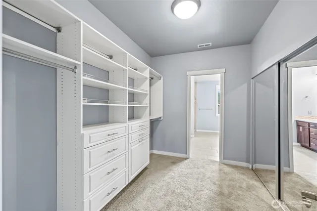 a spacious bathroom with a granite countertop sink a large mirror and a bathtub