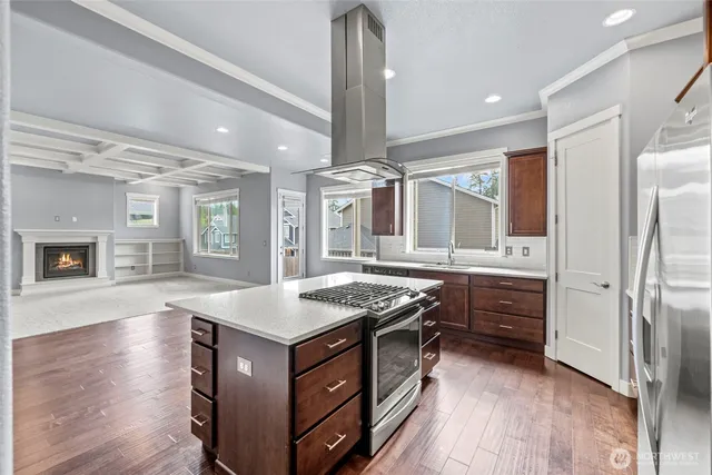 a kitchen with stainless steel appliances granite countertop a sink a stove and a refrigerator