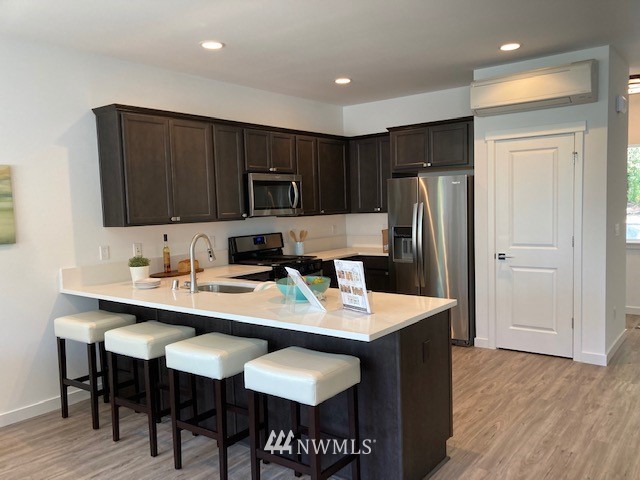 4831 Talbot Road South, Unit A1 Renton, WA 98055 - Photo 29 of 40 a kitchen with stainless steel appliances granite countertop a refrigerator a sink a stove a dining table and chairs