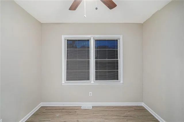 a view of empty room with wooden floor and windows