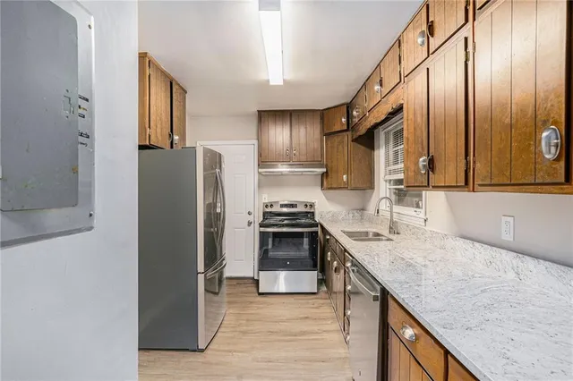 a kitchen with stainless steel appliances granite countertop a sink stove and refrigerator