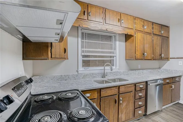 a kitchen with stainless steel appliances granite countertop a sink stove and cabinets