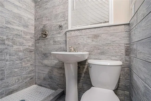 a bathroom with a sink toilet and a mirror