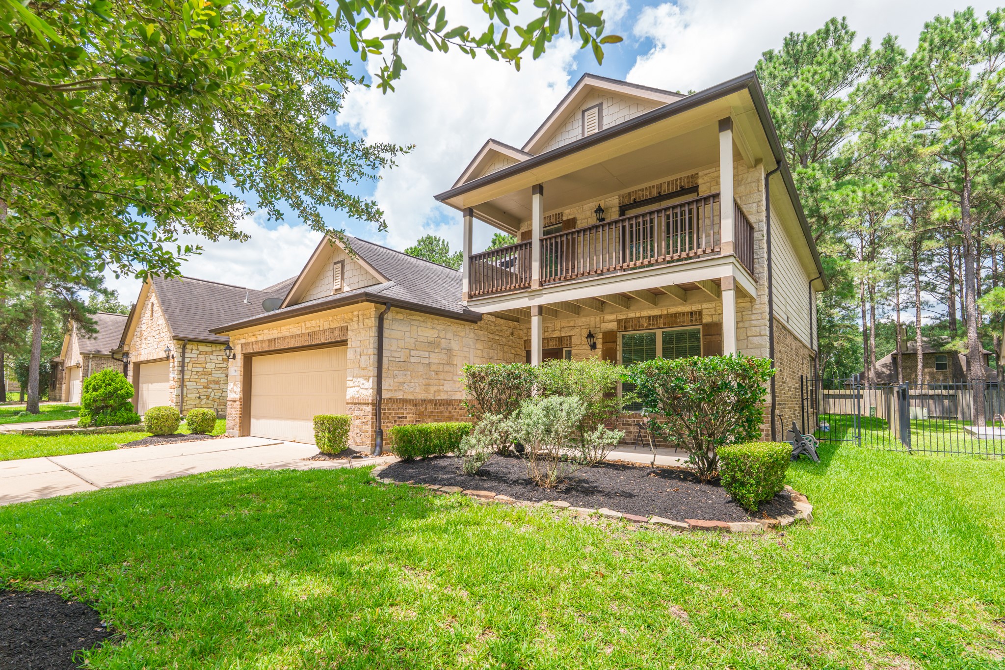 79 West Jagged Ridge Circle Spring, TX 77389 - Photo 6 of 50 This angle captures the home's covered second-floor balcony tucked among tall, mature pine trees, adding a peaceful, retreat-like feel to the exterior. The combination of architectural detail and natural surroundings makes this home feel like a private escape in the middle of Spring.