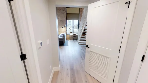 a view of a hallway with wooden floor and staircase