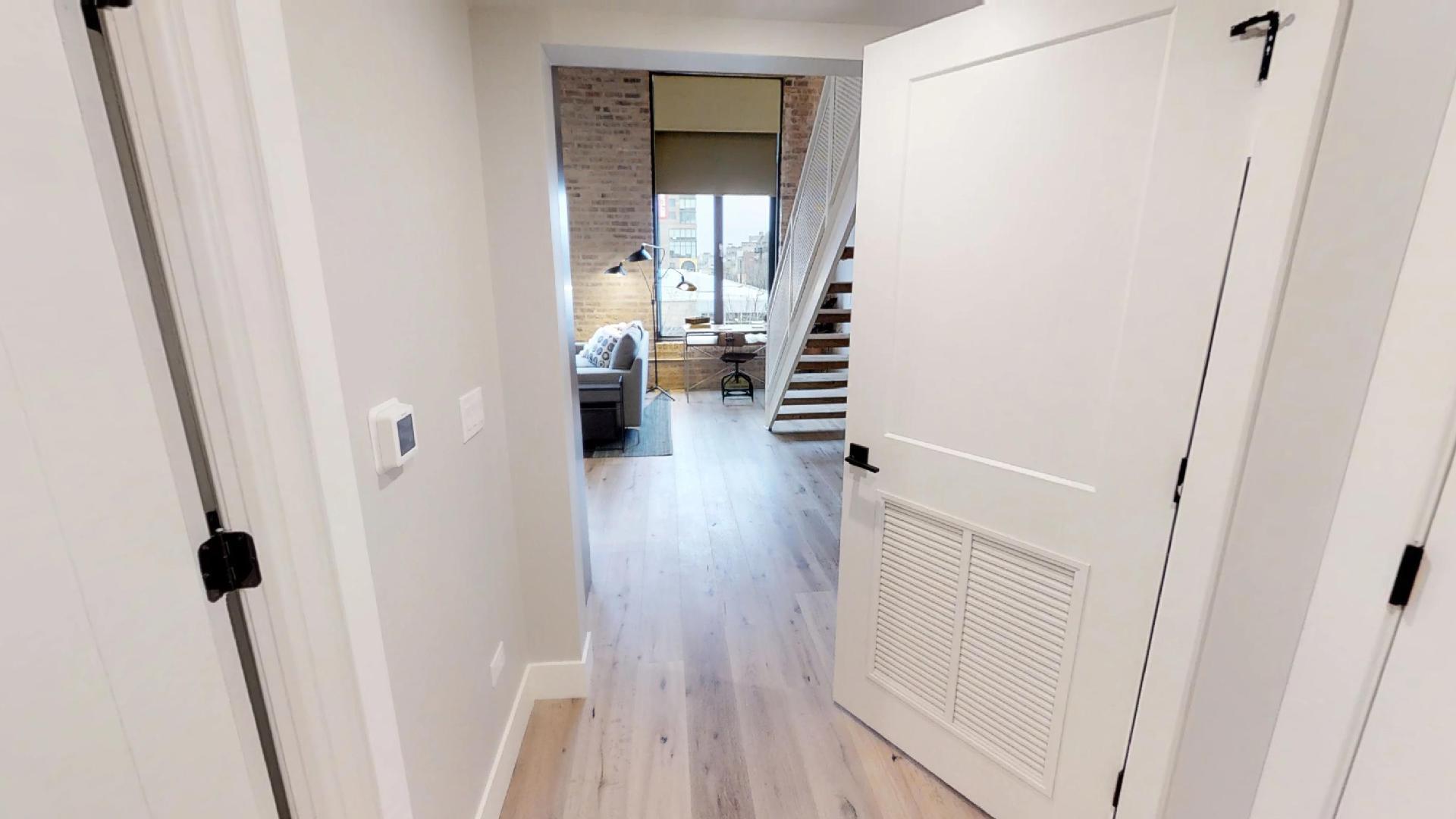 729 North Sangamon Street, Unit 303 Chicago, IL 60642 - Photo 3 of 16 a view of a hallway with wooden floor and staircase