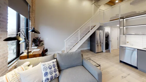 a living room with furniture and stairs