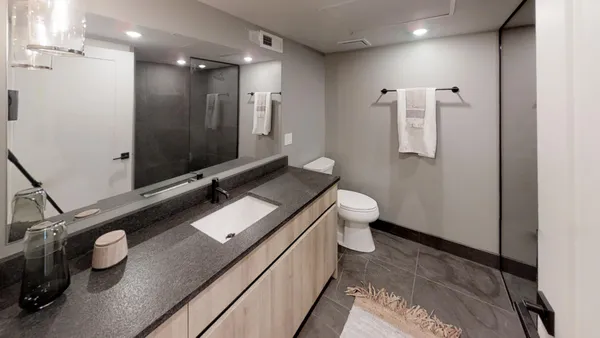 a bathroom with a double vanity sink toilet and mirror