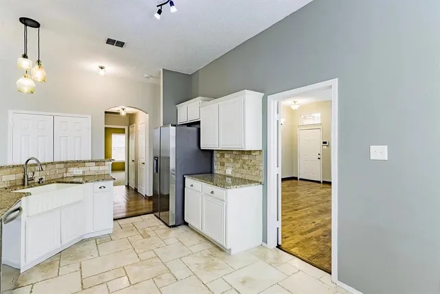 a kitchen with a sink window and cabinets