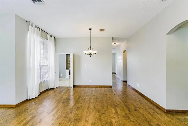 a view of a room with wooden floor a ceiling fan and window