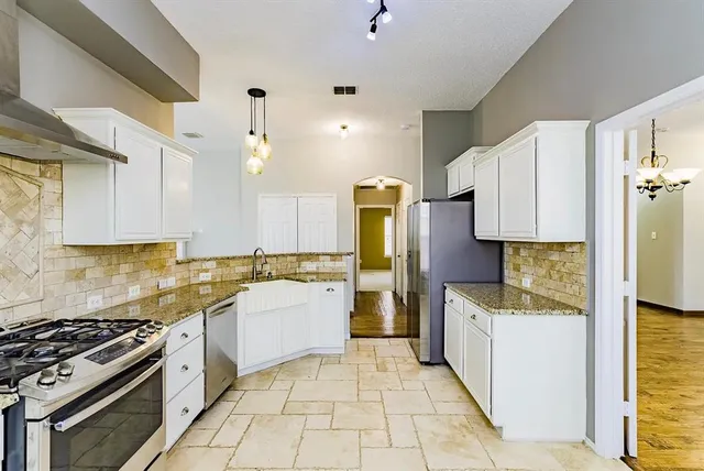 a kitchen with a stove a refrigerator and a sink