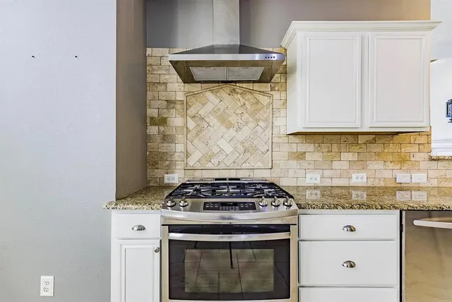 a white stove top oven sitting inside of a kitchen