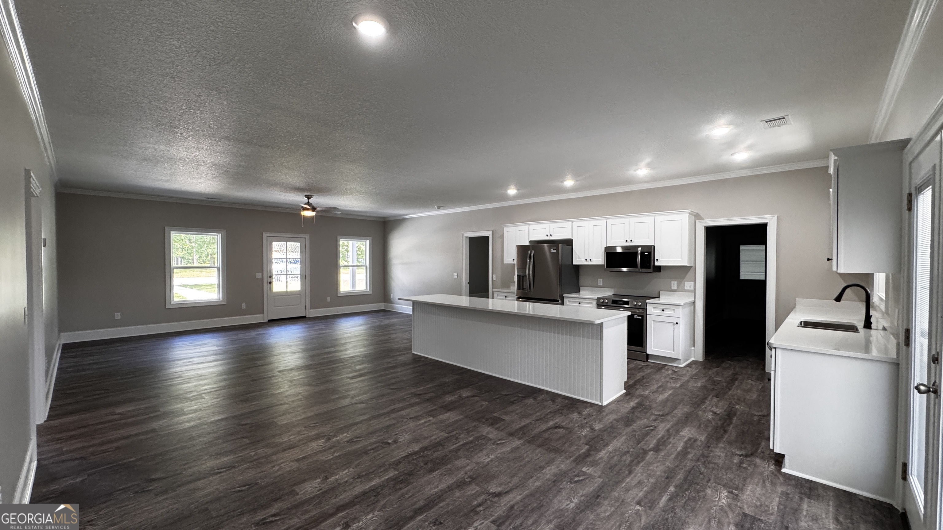 3 Willow Pointe Claxton, GA 30417 - Photo 13 of 31 a kitchen with stainless steel appliances kitchen island granite countertop a stove top oven a refrigerator a sink a dining table and chairs with wooden floor