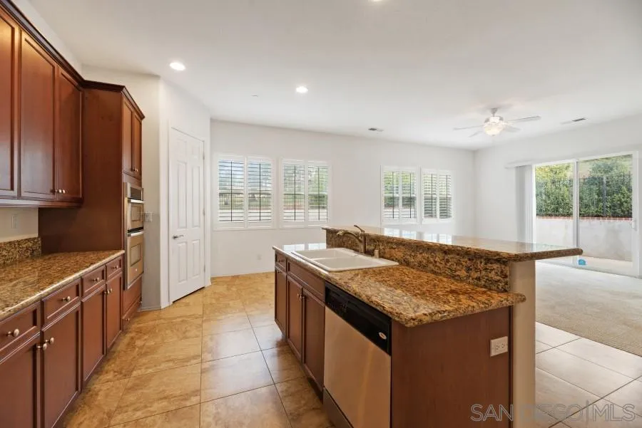 15076 Eastvale Road Poway, CA 92064 - Photo 10 of 35 a kitchen with granite countertop a stove and a sink