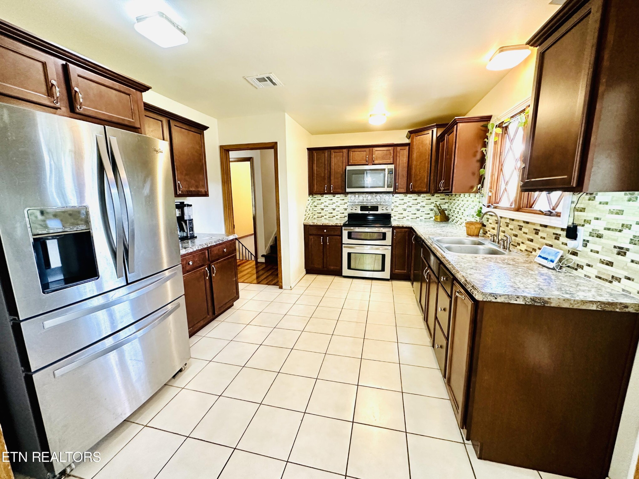 4428 Royalview Road Knoxville, TN 37921 - Photo 6 of 18 a large kitchen with a stove a sink dishwasher a refrigerator and a fireplace