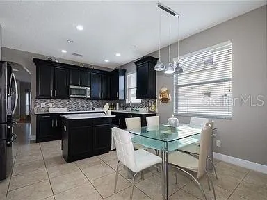 a kitchen with stainless steel appliances granite countertop a stove top oven a sink dishwasher a dining table and chairs