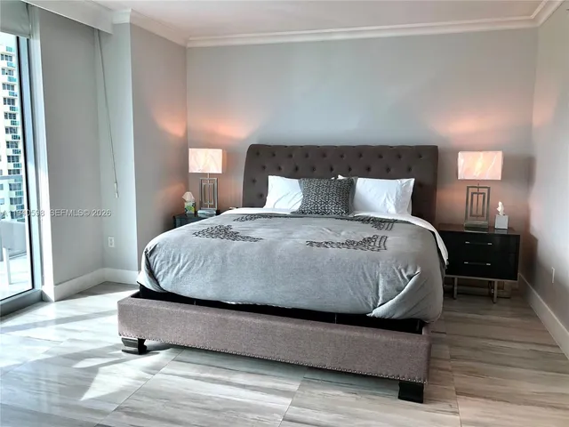 a bedroom with a bed lamp on desk and a window