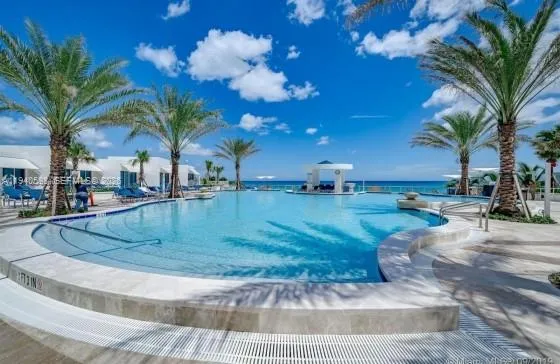 a view of a water fountain with palm trees