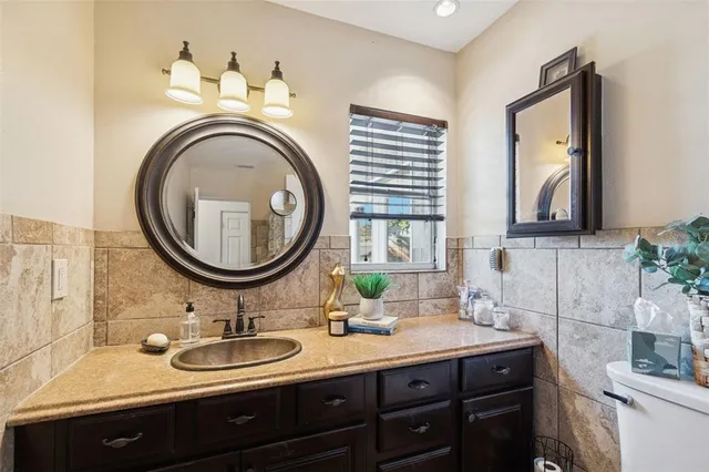 a bathroom with a granite countertop double vanity sink and a mirror
