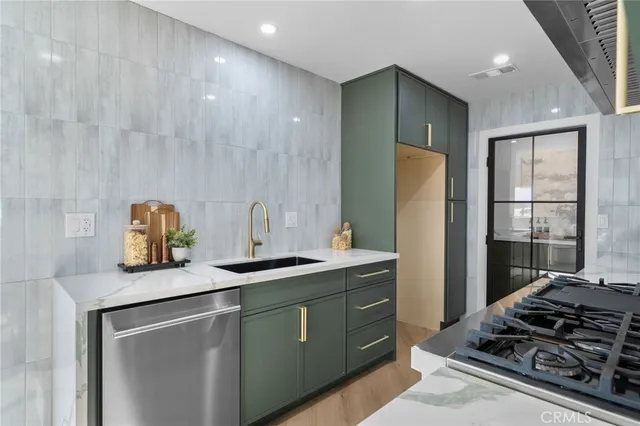 a kitchen with stainless steel appliances granite countertop a sink stove and refrigerator