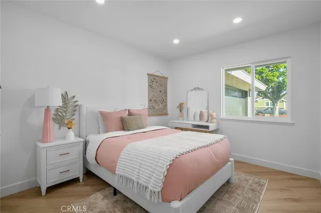 a bedroom with a bed and wooden floor
