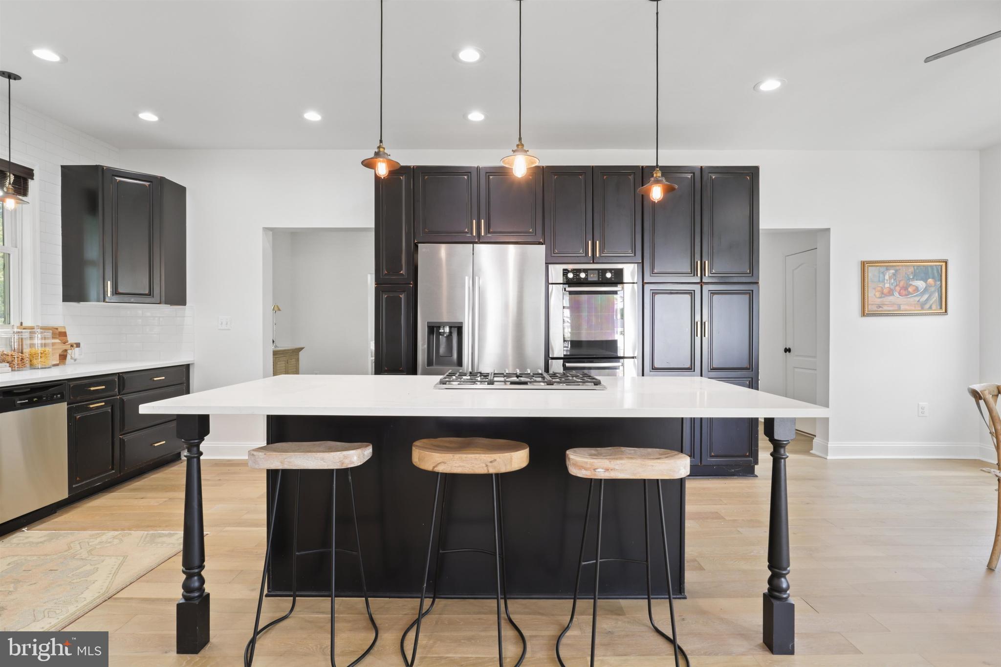 438 Ethan Allen Avenue Takoma Park, MD 20912 - Photo 7 of 47 a kitchen with stainless steel appliances granite countertop a sink a stove a refrigerator and white cabinets with wooden floor