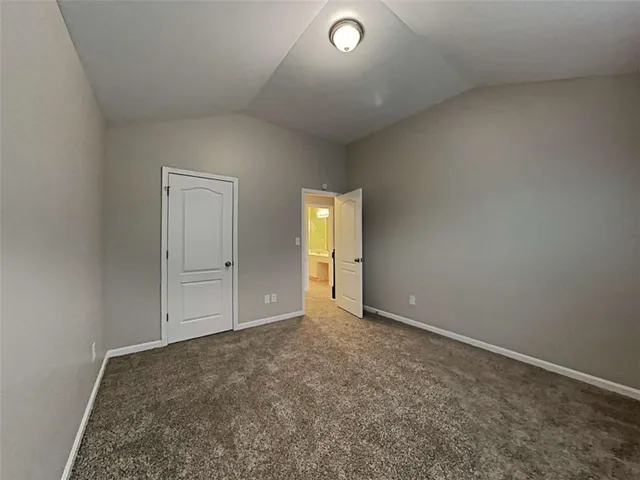an empty room with closet area and mirror