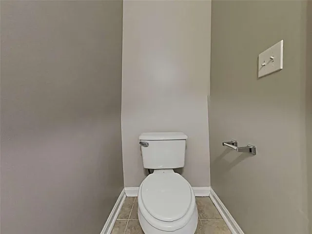 a white toilet sitting next to a white wall