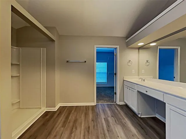 a view of kitchen with wooden floor and cabinets