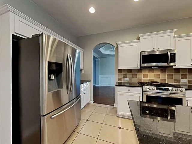 a kitchen with stainless steel appliances granite countertop a refrigerator stove and microwave