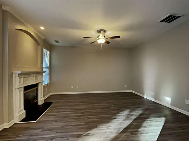 a view of empty room with wooden floor and fireplace