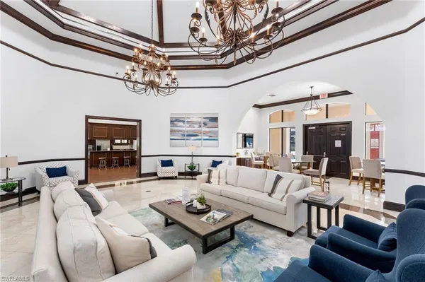 a living room with furniture a chandelier and a flat screen tv