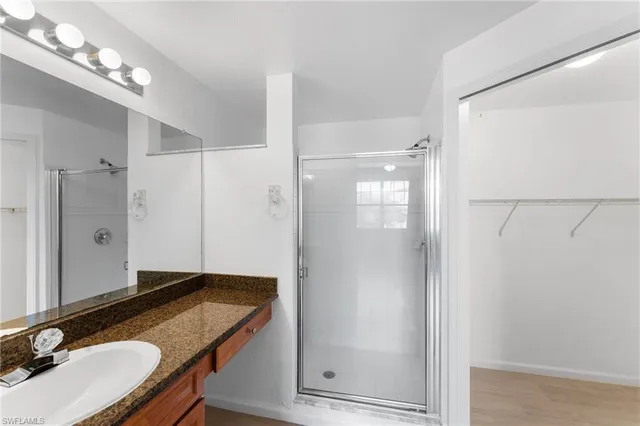 a bathroom with a granite countertop shower sink and mirror
