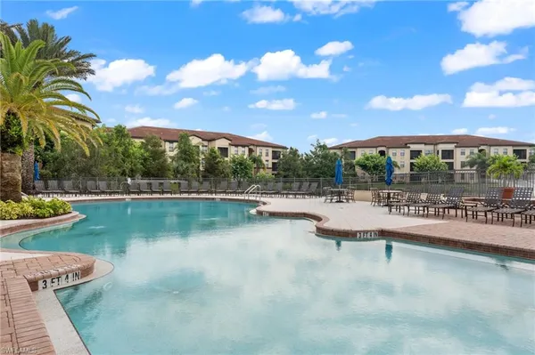 a view of a swimming pool with outdoor seating and plants