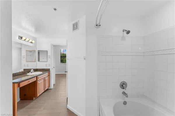 a bathroom with a granite countertop sink a toilet and shower
