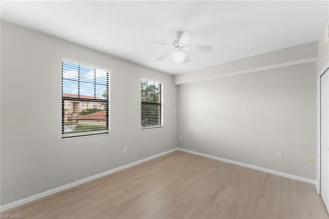 an empty room with windows and fan