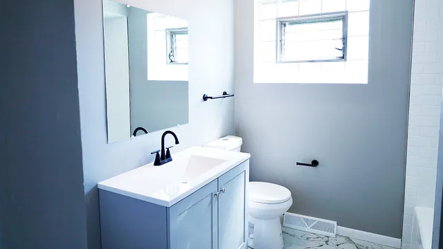 a bathroom with a toilet sink and mirror