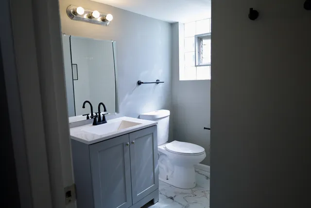 a bathroom with sink a toilet and mirror